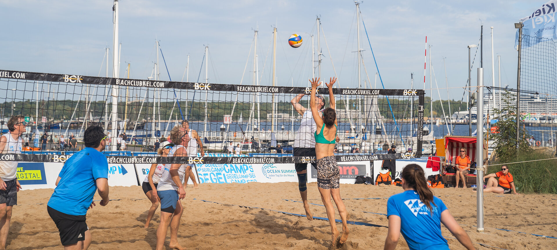 Zwei Teams spielen Beachvolleyball im Segelcamp
