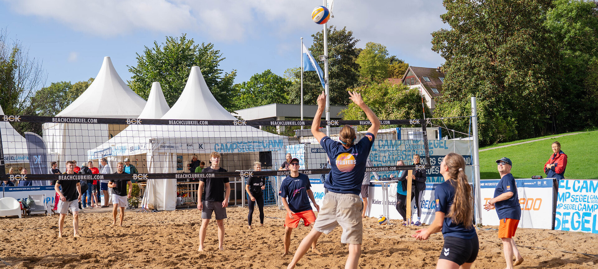 Zwei Teams spielen Beachvolleyball im Segelcamp
