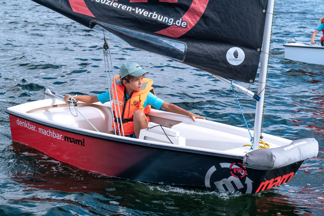 Junge sitzt im Opti in einem Kurs vom Segelcamp Kiel