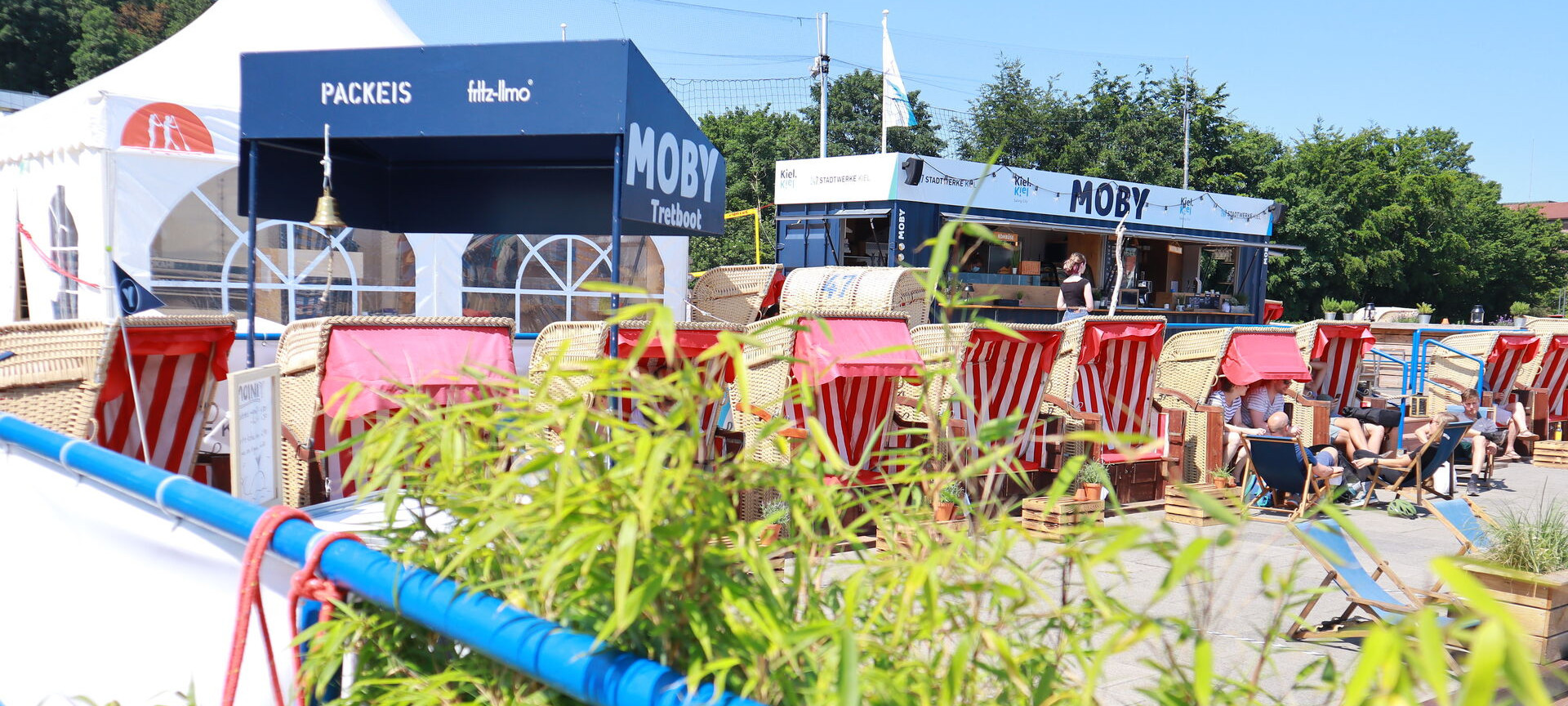 Vier Kinder sitzen im Strandkorb und essen Eis am Stiel bei Moby