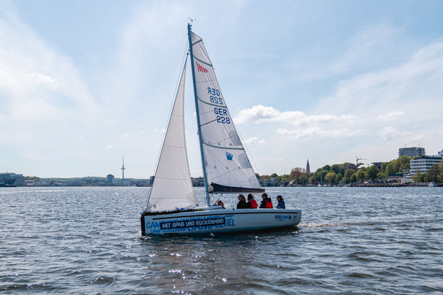 Vier junge Menschen und einem Segeltrainer auf der Aira 22 in einem Kurs vom Segelcamp Kiel