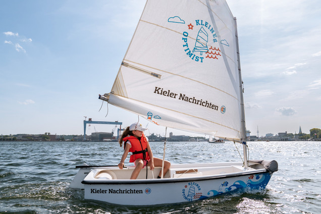 Mädchen sitzt im Opti in einem Kurs vom Segelcamp Kiel