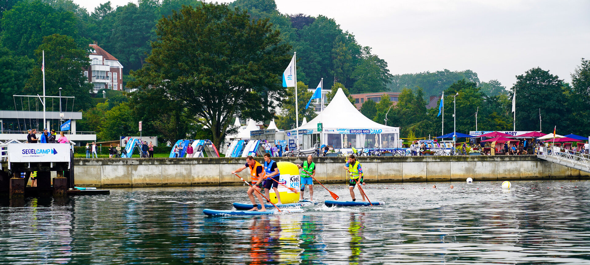 Menschen auf SUP Boards auf der Kieler Förde vor dem Segelcamp