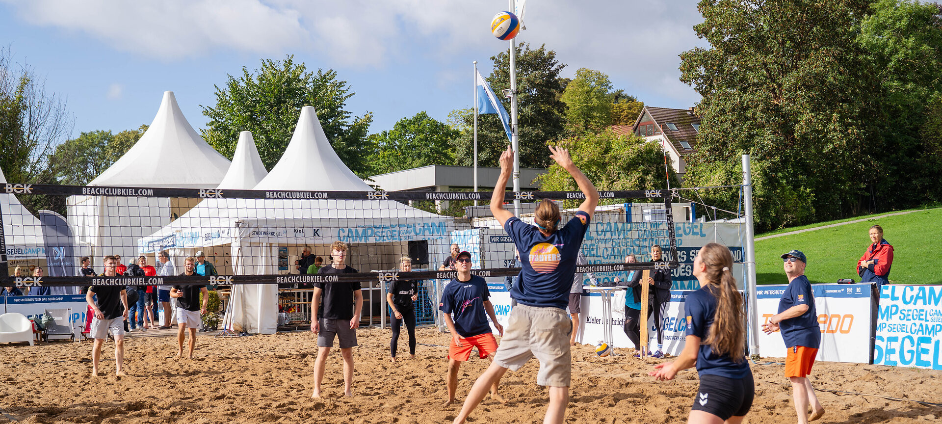 Zwei Teams spielen Beachvolleyball im Segelcamp
