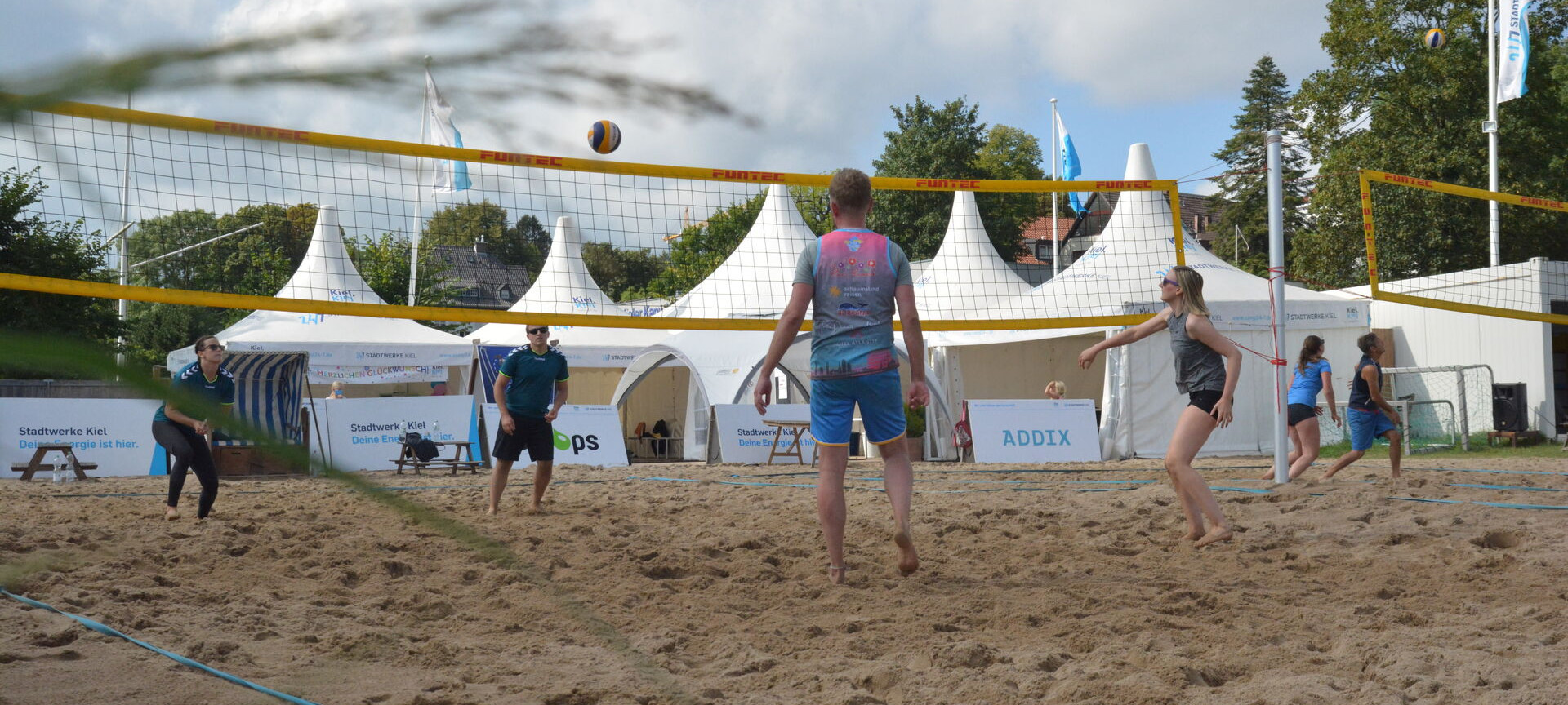 Zwei Teams spielen Beachvolleyball im Segelcamp